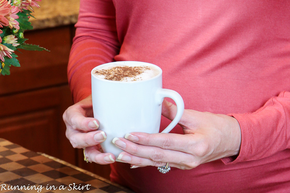 Dirty Chai Latte in a mug with hands holding it.